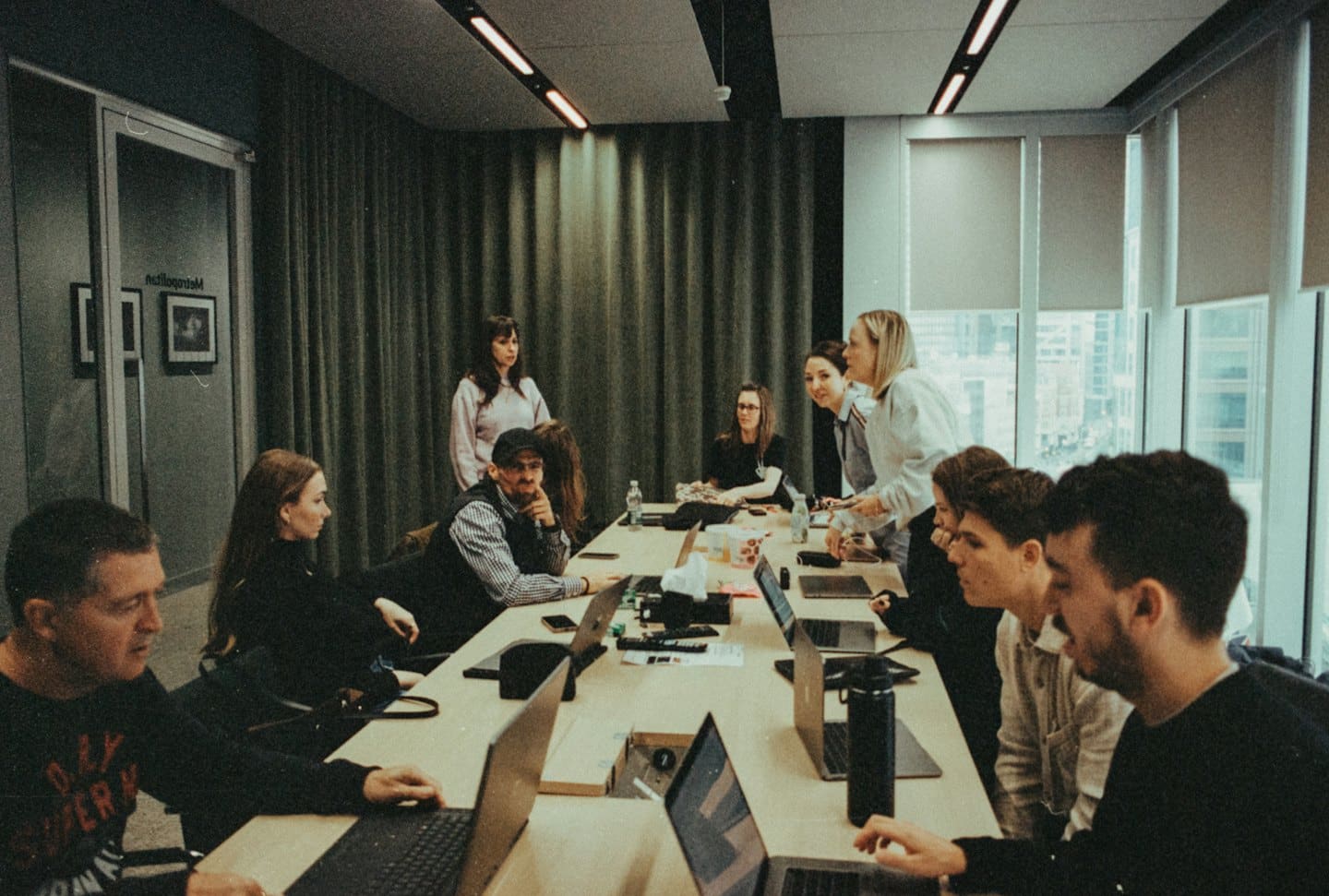 Des professionnels discutent autour d'une table en bois dans un bureau.